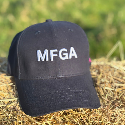 Black cap with 'MFGA' on a hay bale with a blurred green background