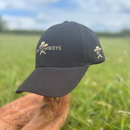 Black cap with 'Cowboys' logo on a grassy field