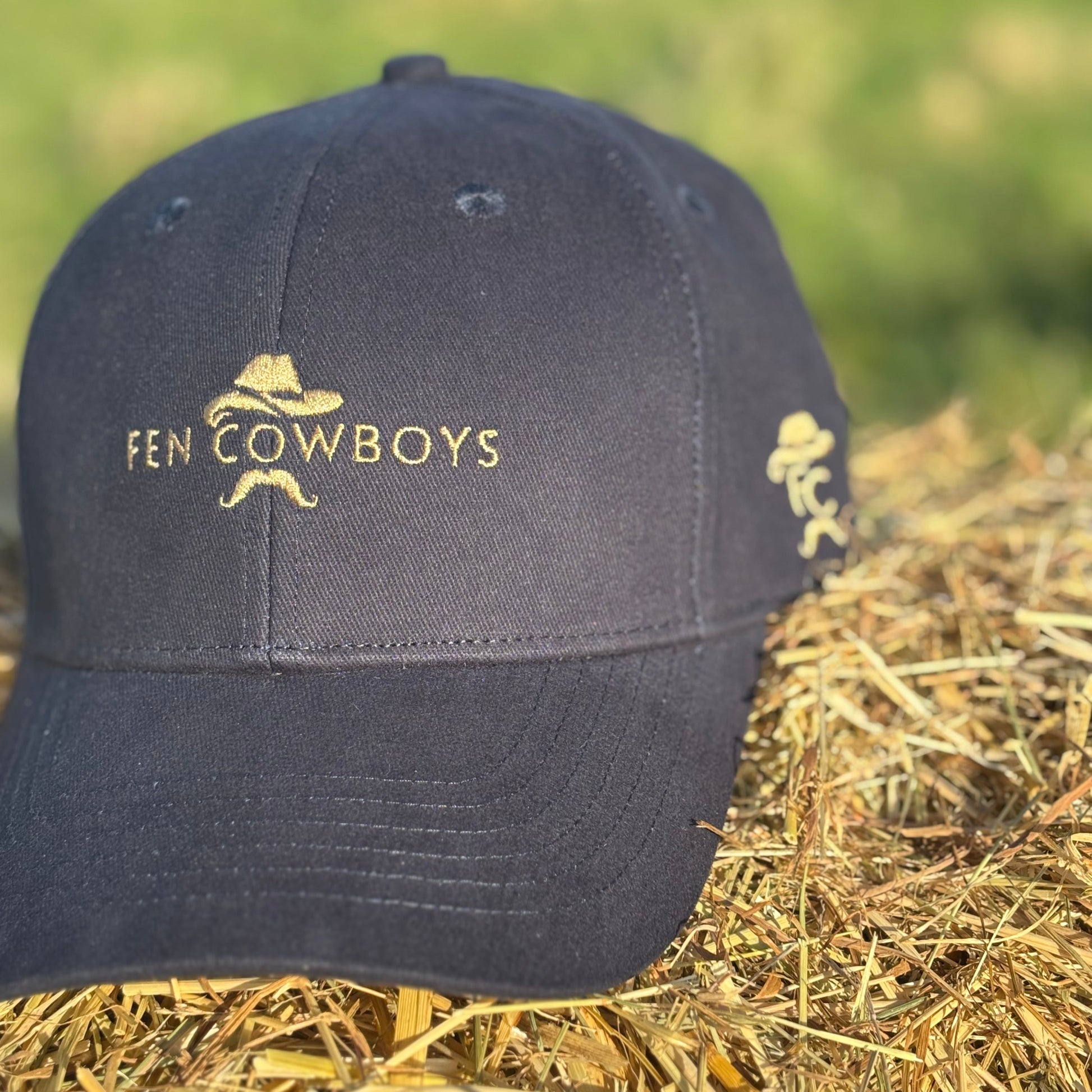 Black cap with 'Fen Cowboys' logo on a hay bale
