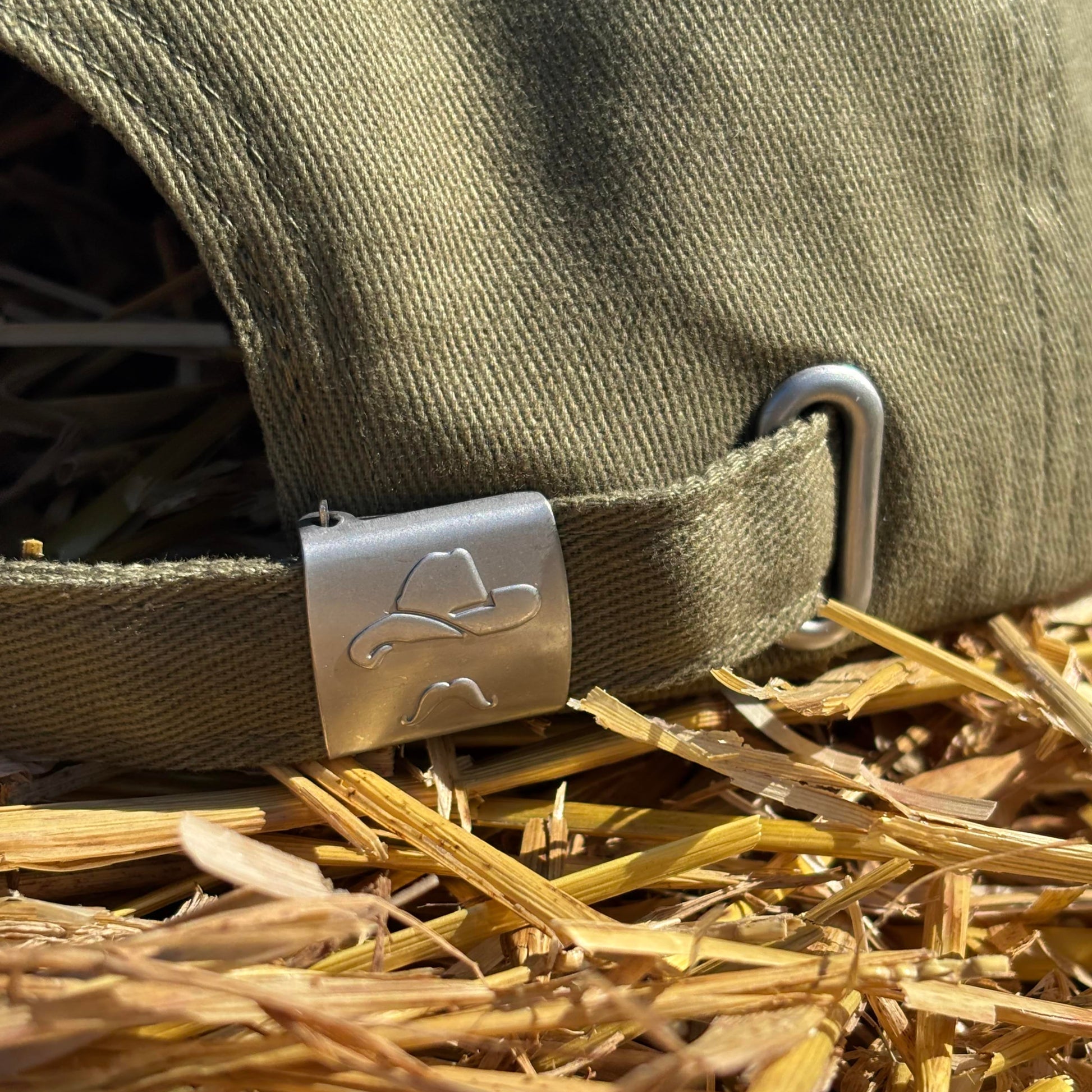 Close-up of a green strap with a metal buckle on a textured background