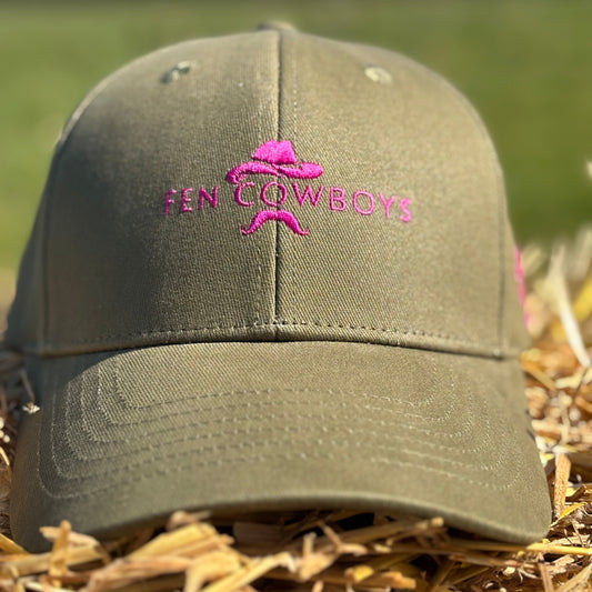 Green cap with pink logo and text on a grassy background