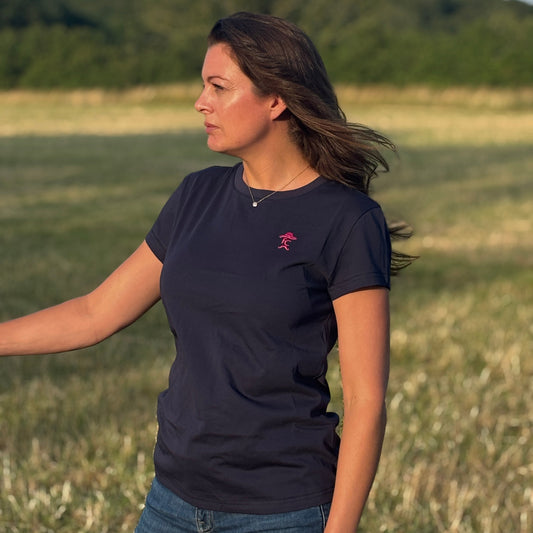 Woman wearing a navy blue t-shirt with a logo in a field
